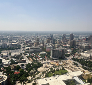 Stadtpanorama von San Antonio, Texas, mit Hochhäusern, Straßenverläufen und Bauflächen bei klarem Himmel.