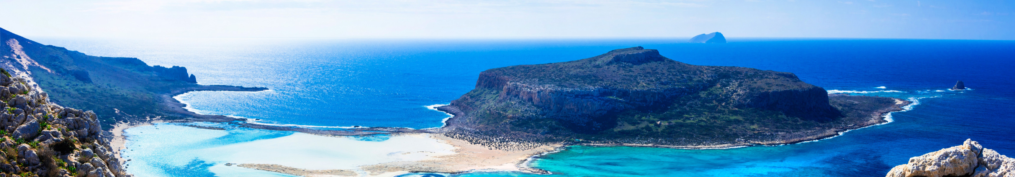 Panorama der Lagune von Balos auf Kreta mit türkisfarbenem Wasser, weißem Sandstrand und felsiger Küstenlandschaft.