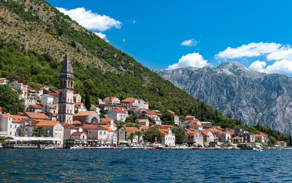 K&uuml;ste mit Dorf und Kirchturm im Montenegro Urlaub am Meer