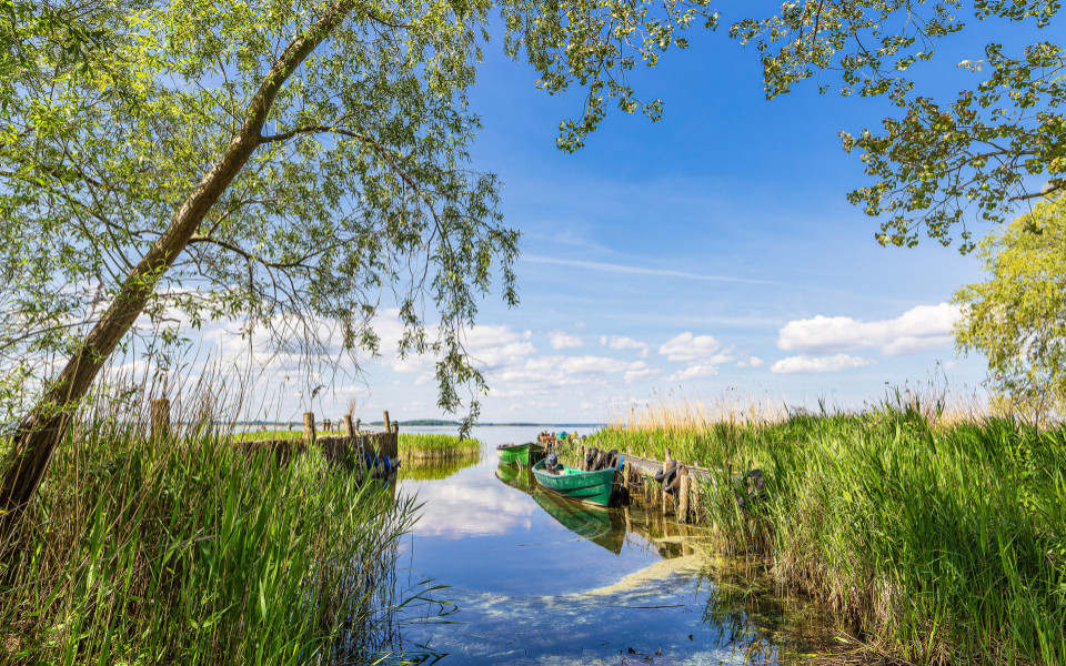 Steg mit Fischerboot am Achterwasser bei Warthe auf der Insel Usedom in Deutschland